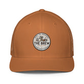 The Brew Collective trucker cap in orange with logo showcasing coffee and brewing accessories.